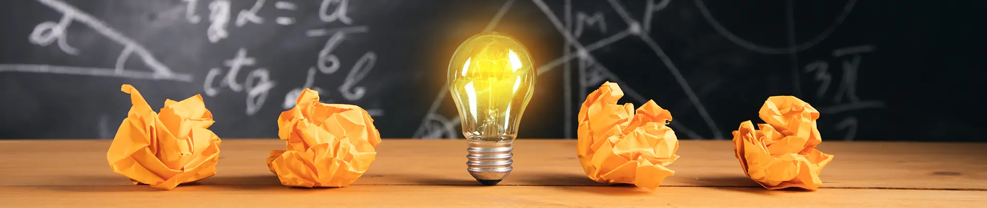 Imatge de fons d'unes bombetes il·luminades en una aula escolar.